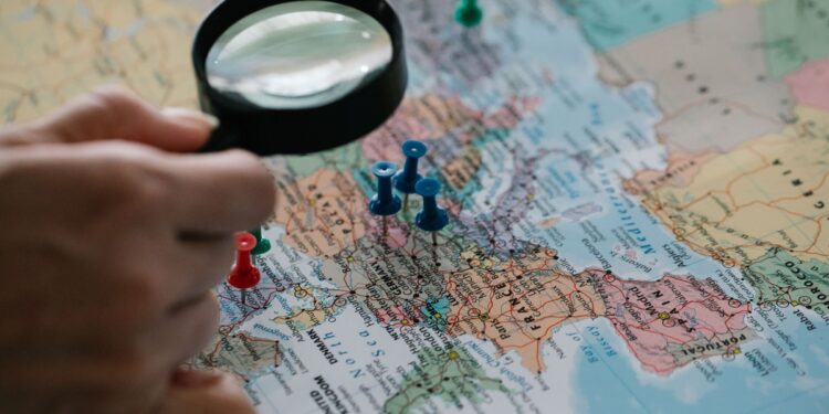World map with route pins and travel planning flat lay